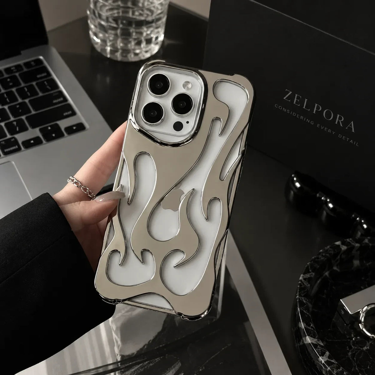 Zelpora silver chrome flame iPhone case with a translucent frosted finish and raised metallic detailing.